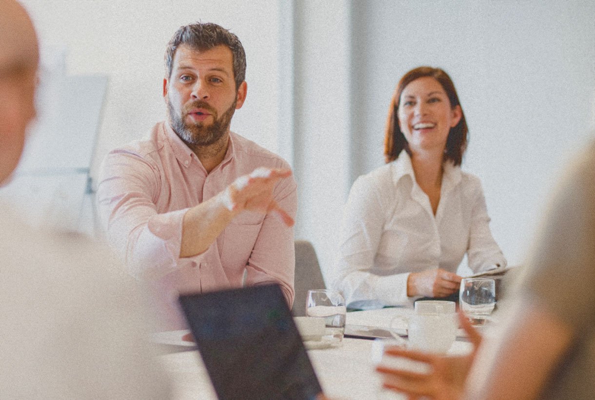 People listening and sharing ideas around a meeting table